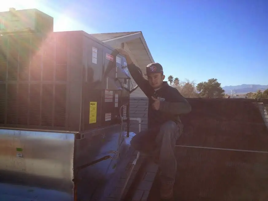 HVAC technician performing HVAC Inspection on a rooftop unit in Tichigan